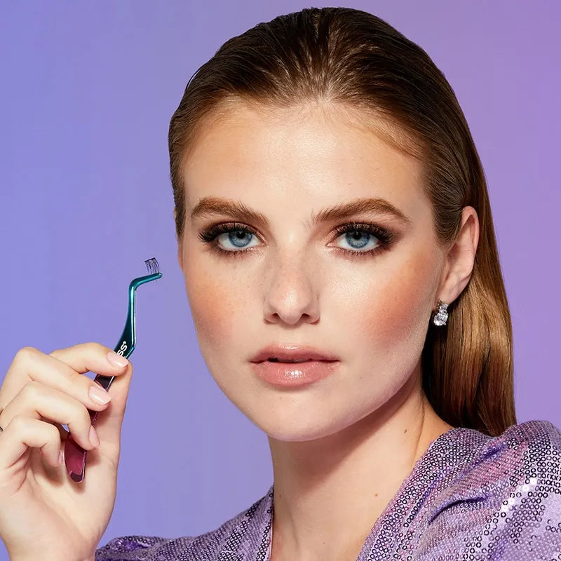 A woman is holding Falscara eyelash applicator in her hand.