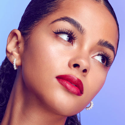 A woman modeling Falscara Studio lashes from the "Xtra Collection". Lashes are full with curl and volume that replicates a lash extension look.