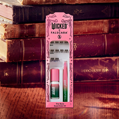 Wicked Falscara essentials kit with false lashes and applicator on vintage book background.