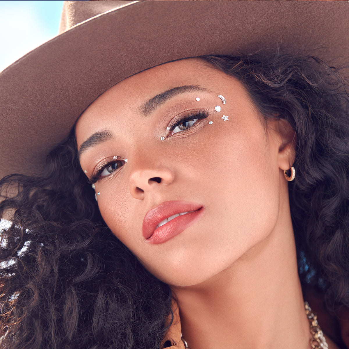 Woman wearing a brown hat with decorative elements on her face
