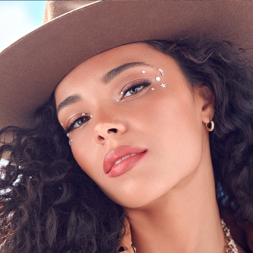 Woman wearing a brown hat with decorative elements on her face