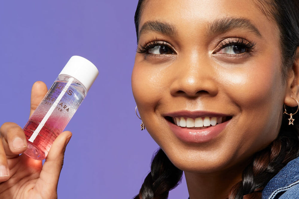 A woman holding up a bottle of Falscara's beest selling false lash remover. Photo represents the Best Selling collection from Falscara.