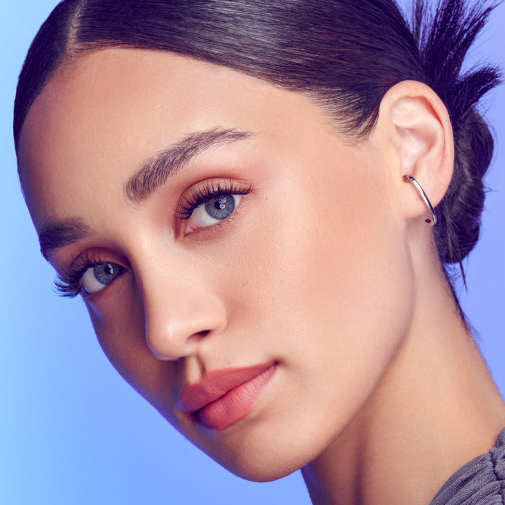 A woman wearing false lashes that look full and curly with a delicate effect. Lashes are from Falscara Studio Delicate collection. 