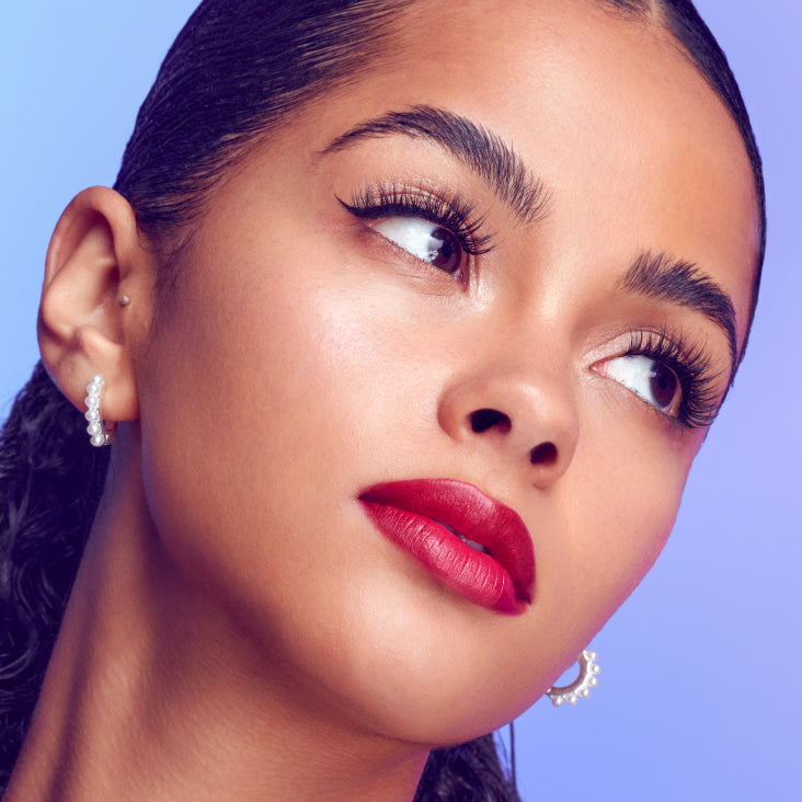 A woman modeling Falscara Studio lashes from the "Xtra Collection". Lashes are full with curl and volume that replicates a lash extension look. 