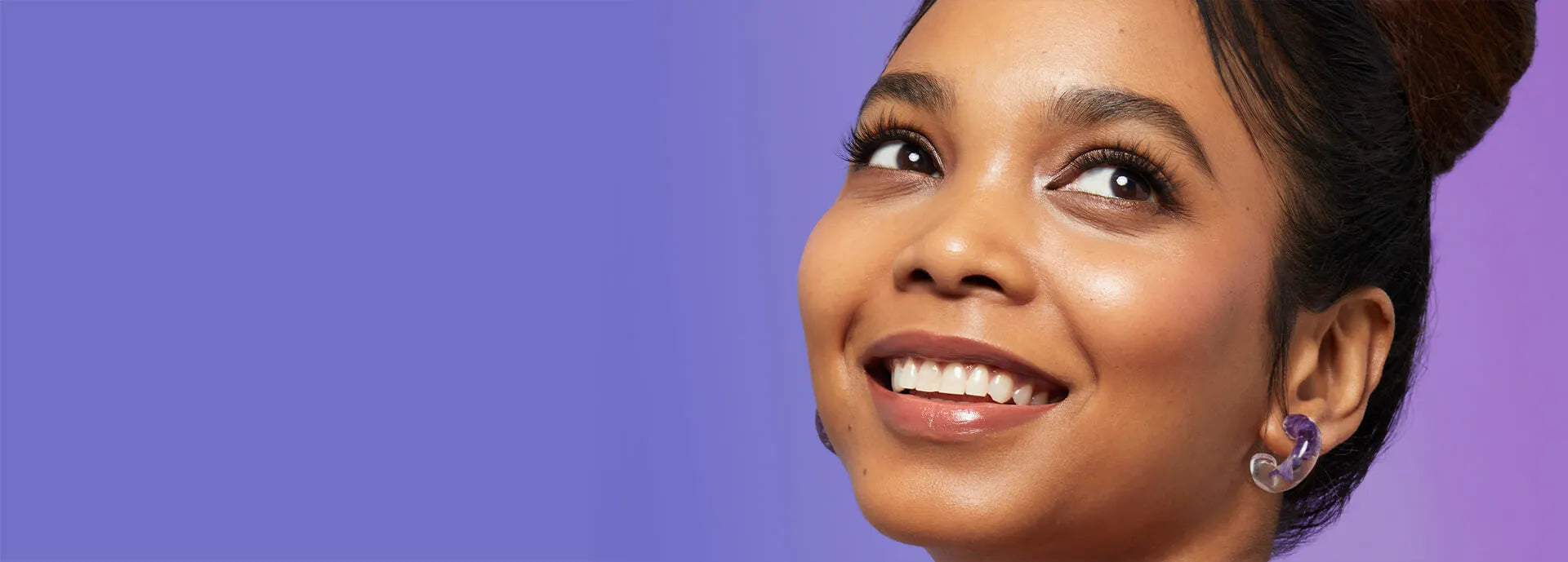 A woman smiling and wearing Falscara lashes that are full, voluminous and wispy.