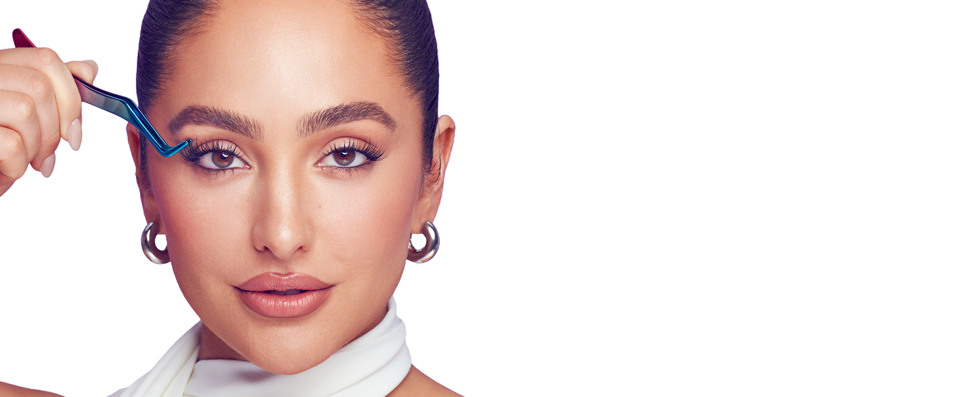Brand Ambassador and celebrity makeup artist, Ash K Holm using a lash applicator to apply false lash wisps from Falscara under her natural lashes.