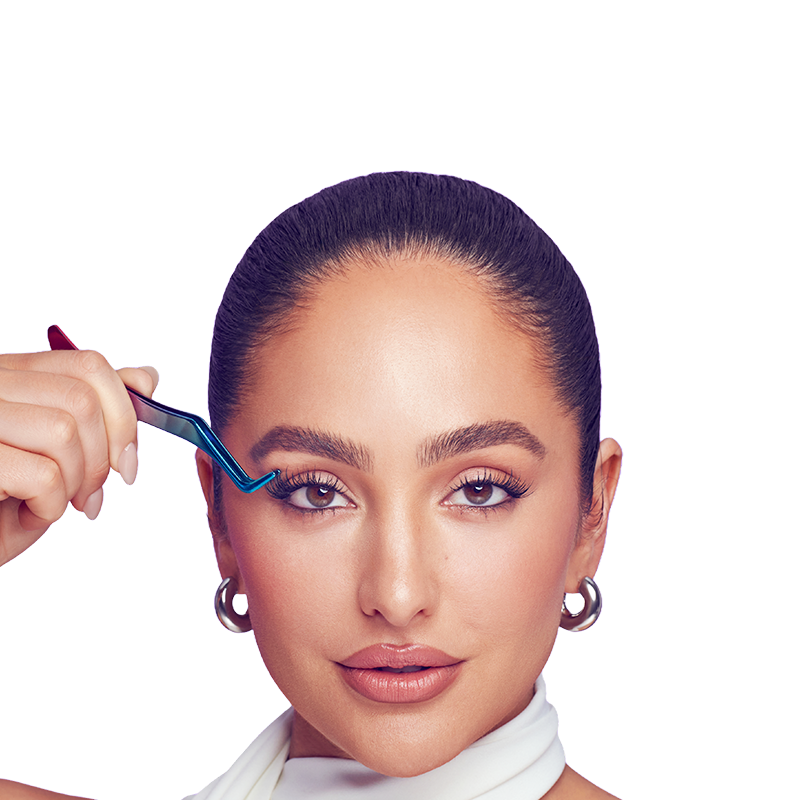 Brand Ambassador and celebrity makeup artist, Ash K Holm modeling Falscara lashes that apply under natural lashes for a seamless effect. She's holding the Falscara lash applicator she used to apply the lashes.